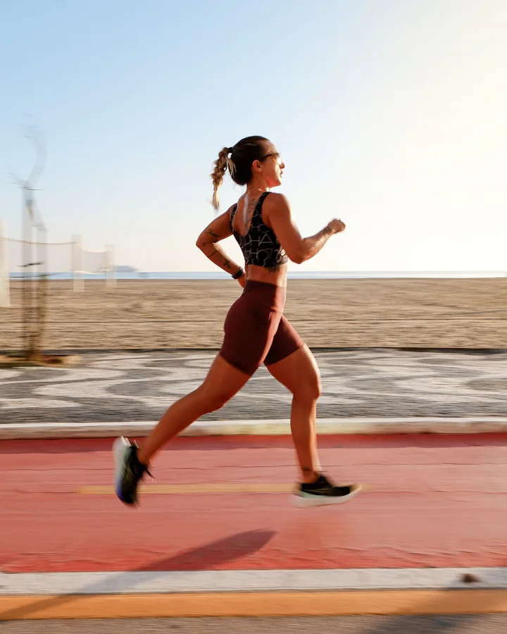 Atleta correndo em uma pista à beira-mar
